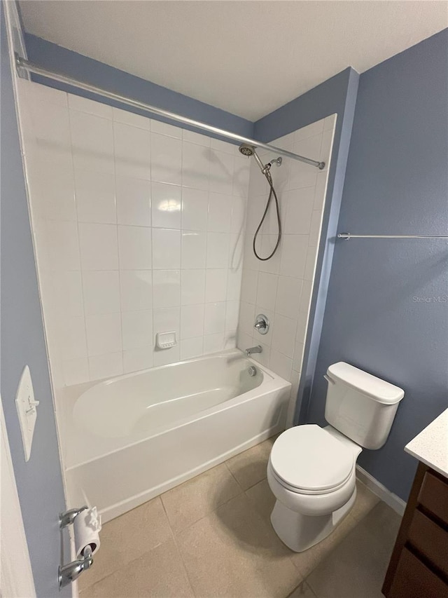 full bathroom with tile patterned floors, vanity, tiled shower / bath combo, and toilet