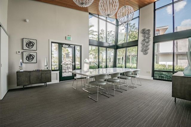 carpeted dining room featuring a wealth of natural light and a high ceiling