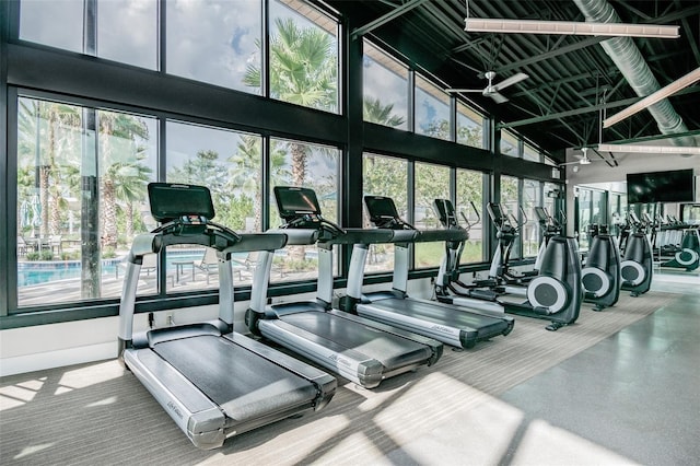 gym featuring ceiling fan, high vaulted ceiling, and a healthy amount of sunlight