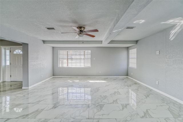 unfurnished room with beam ceiling, ceiling fan, and a textured ceiling