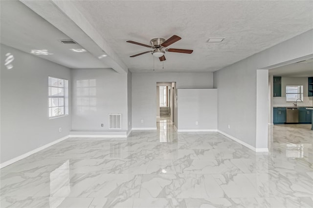 spare room featuring a textured ceiling, ceiling fan, and sink