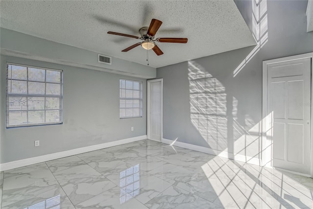 empty room with ceiling fan and a healthy amount of sunlight