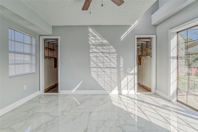 empty room with ceiling fan and a textured ceiling