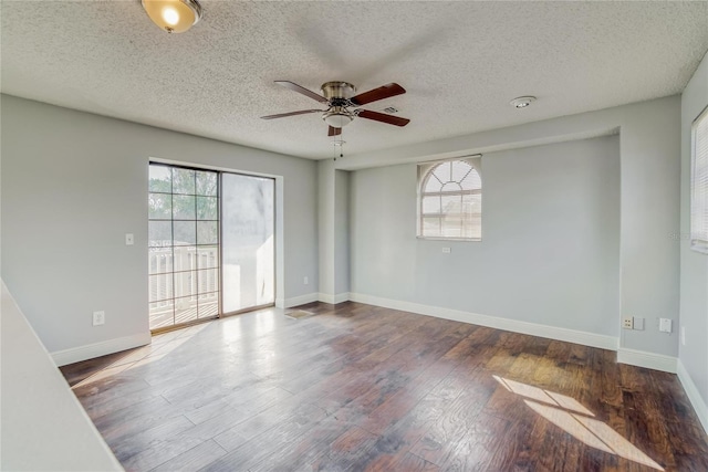 spare room with ceiling fan, a healthy amount of sunlight, and dark wood-type flooring