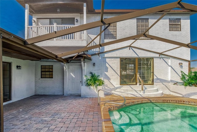 rear view of house featuring a patio area and a balcony