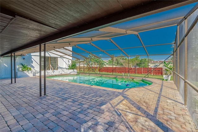 view of swimming pool featuring a lanai and a patio area