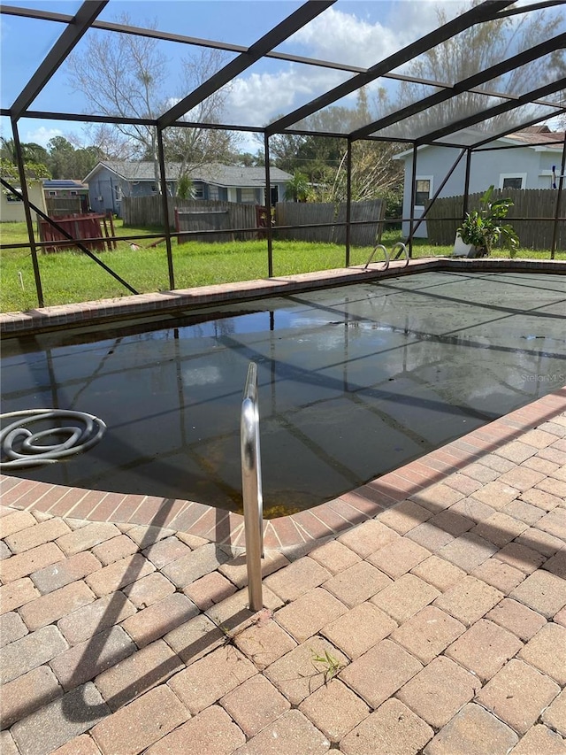 view of swimming pool featuring a yard and a lanai