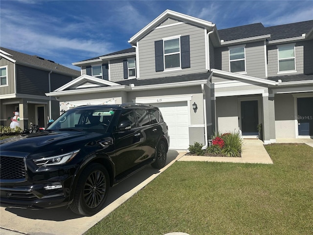 townhome / multi-family property featuring a front yard and a garage