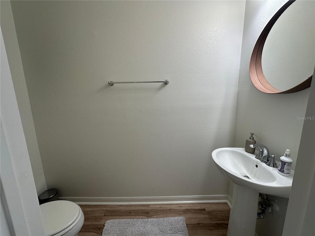 bathroom with hardwood / wood-style flooring and toilet