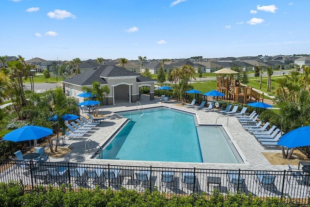 view of swimming pool with a playground and a patio area