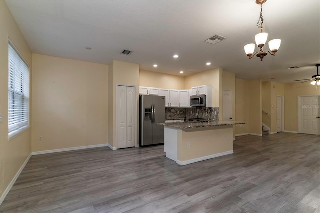 kitchen featuring light stone countertops, appliances with stainless steel finishes, decorative light fixtures, light hardwood / wood-style floors, and white cabinetry