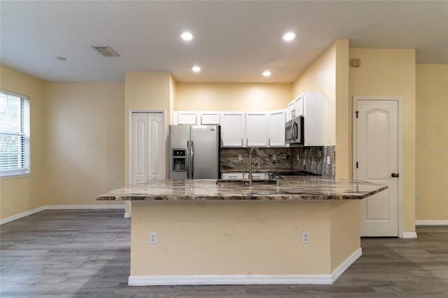 kitchen with backsplash, stone counters, white cabinets, sink, and stainless steel appliances