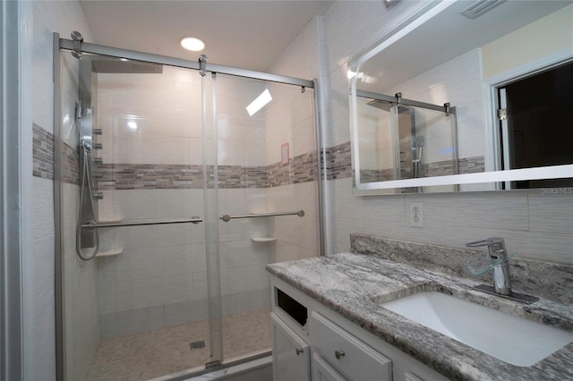 bathroom with vanity and a shower with shower door