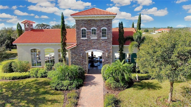 mediterranean / spanish-style house with a front yard