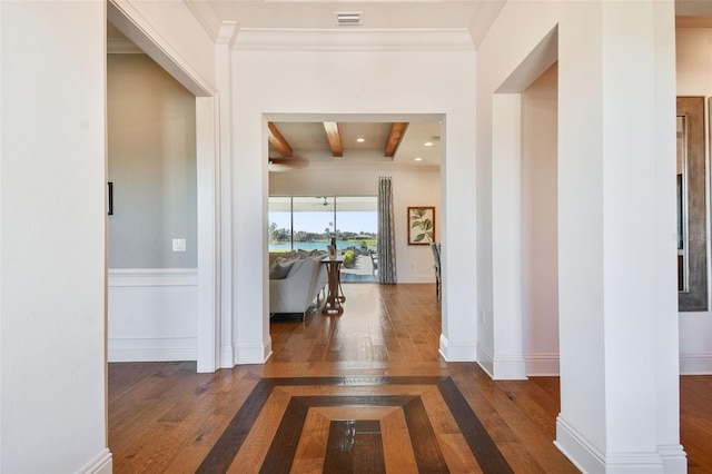 hall with beam ceiling, crown molding, and dark wood-type flooring