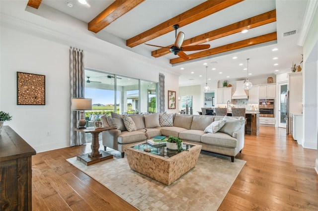 living room featuring light hardwood / wood-style floors, ceiling fan, and ornamental molding