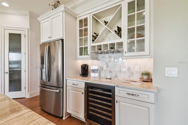 bar featuring wine cooler, stainless steel fridge with ice dispenser, light stone counters, decorative backsplash, and white cabinets