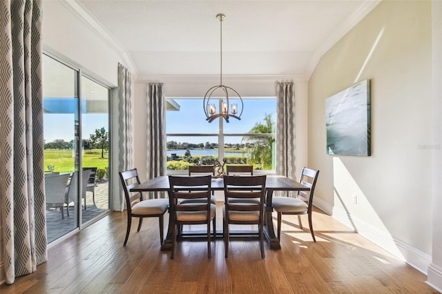 dining area featuring a chandelier, dark hardwood / wood-style floors, crown molding, and a water view