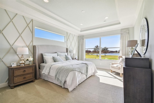 carpeted bedroom with a tray ceiling and crown molding