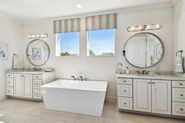 bathroom featuring a bathing tub, vanity, crown molding, and tile patterned floors