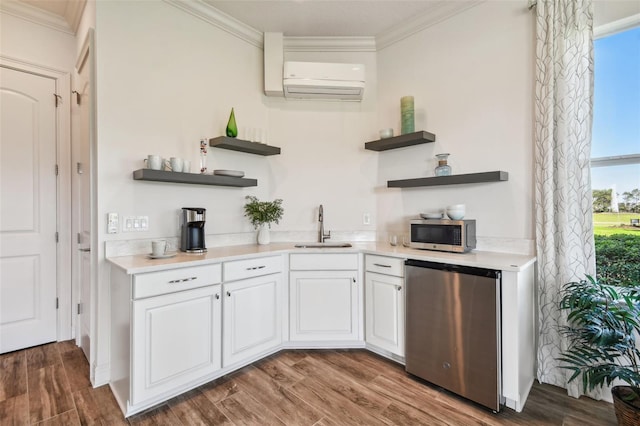 kitchen with sink, stainless steel appliances, a wall mounted air conditioner, white cabinets, and hardwood / wood-style flooring