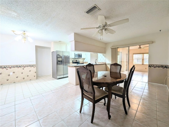 dining space featuring light tile patterned floors, a textured ceiling, ceiling fan, and sink