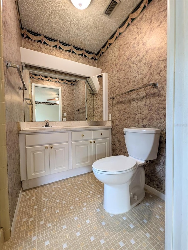 bathroom with vanity, a textured ceiling, and toilet