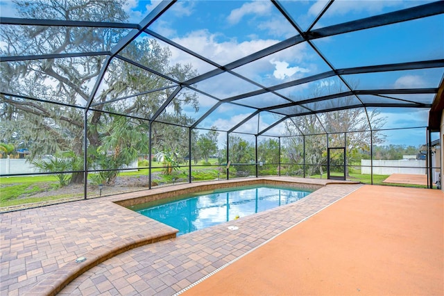 view of pool featuring glass enclosure and a patio area