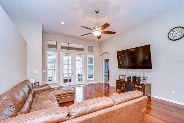 living area featuring ceiling fan, baseboards, hardwood / wood-style floors, french doors, and arched walkways