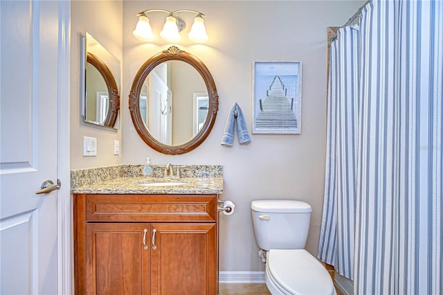 bathroom with vanity, curtained shower, toilet, and baseboards