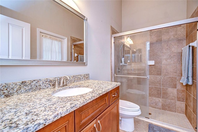 bathroom featuring vanity, tile patterned floors, toilet, and a stall shower