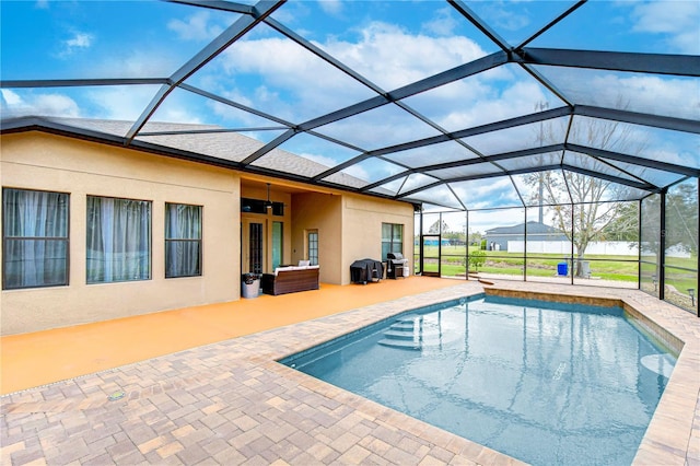 outdoor pool with a grill, a lanai, and a patio area