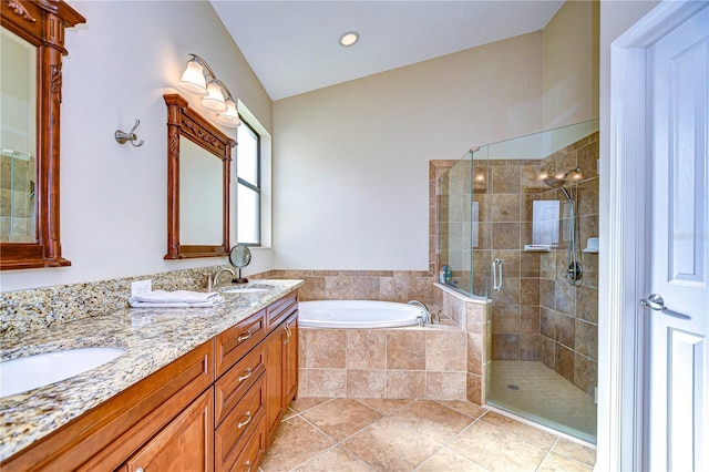 bathroom with a sink, double vanity, a stall shower, and a garden tub