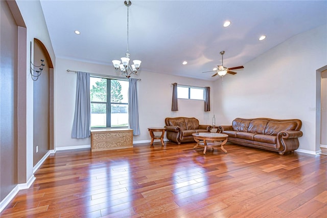 living room featuring baseboards, recessed lighting, hardwood / wood-style floors, arched walkways, and ceiling fan with notable chandelier