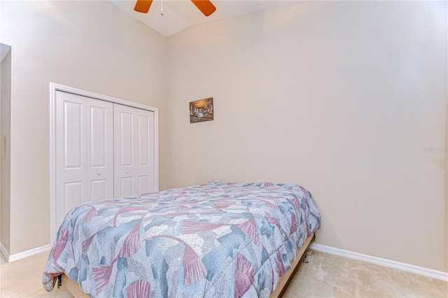 carpeted bedroom with a closet, high vaulted ceiling, baseboards, and a ceiling fan