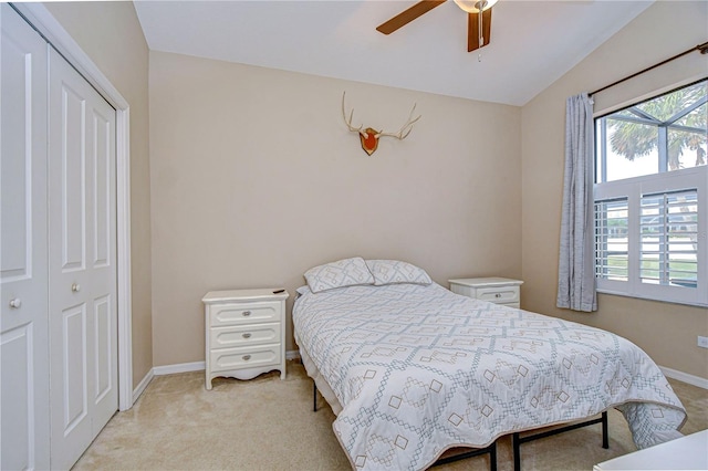 bedroom with ceiling fan, light colored carpet, baseboards, and vaulted ceiling