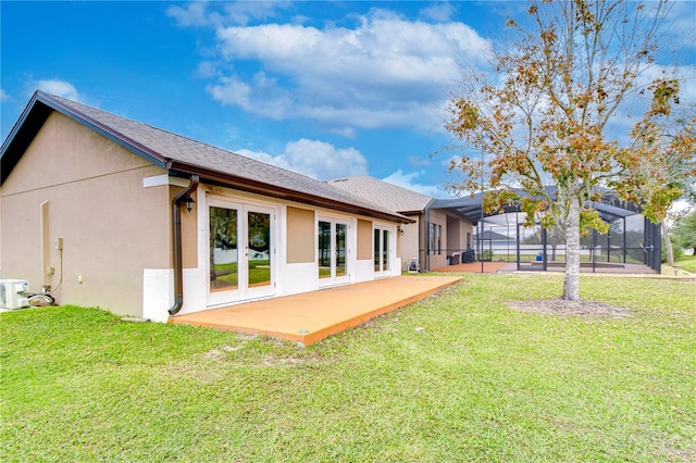 rear view of property with stucco siding, a lawn, a patio area, a lanai, and french doors