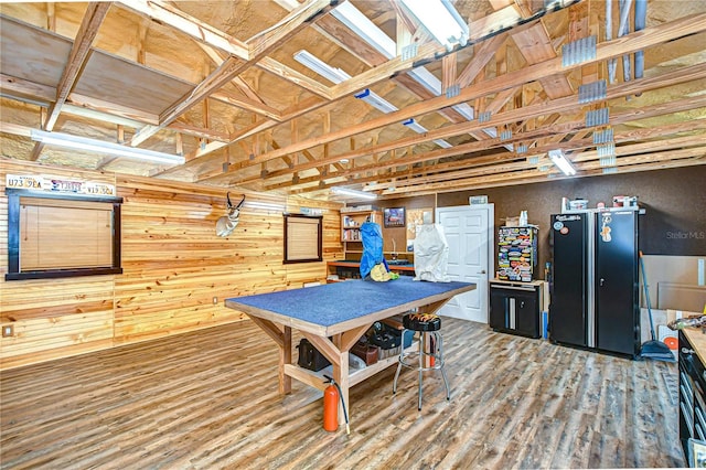game room with wood finished floors and wood walls