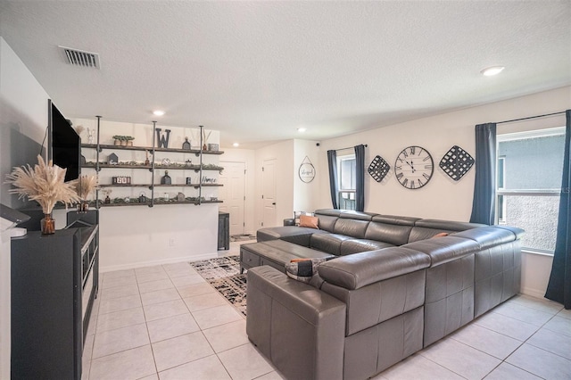 living room with a textured ceiling and light tile patterned flooring