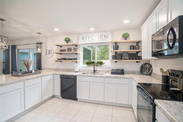 kitchen with sink, black appliances, pendant lighting, light tile patterned floors, and white cabinetry