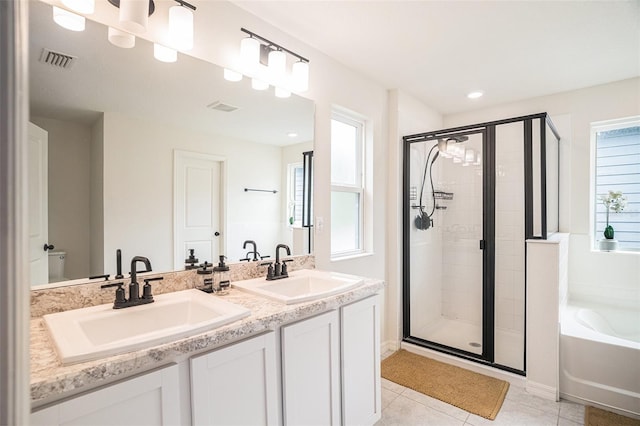 full bathroom featuring tile patterned floors, vanity, independent shower and bath, and a wealth of natural light