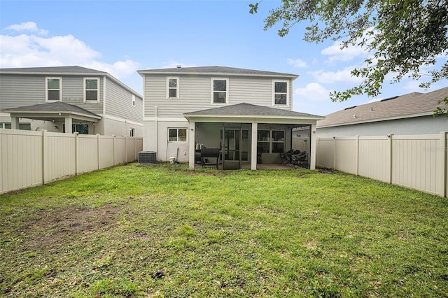 rear view of property with central air condition unit, a lawn, and a sunroom