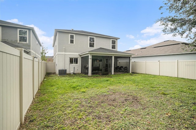 rear view of property featuring a lawn, a sunroom, and cooling unit