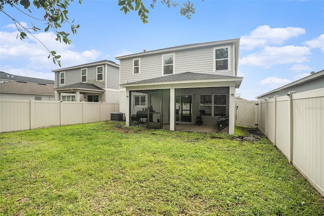 rear view of property with a sunroom, a yard, and central AC unit