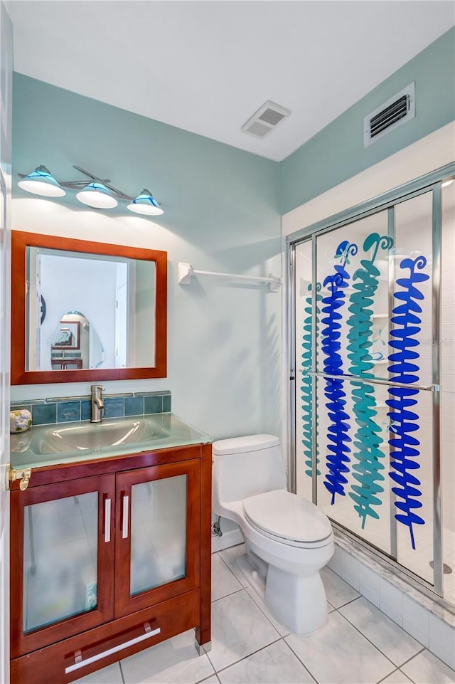 bathroom with toilet, tile patterned floors, and a shower with shower door