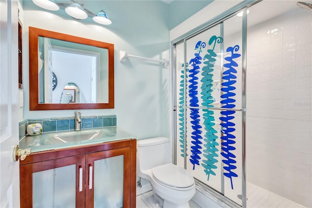 bathroom featuring vanity, toilet, and a shower with shower door