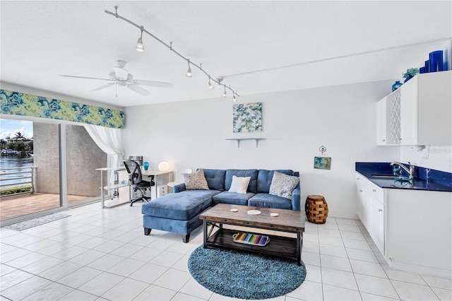 tiled living room featuring ceiling fan and sink