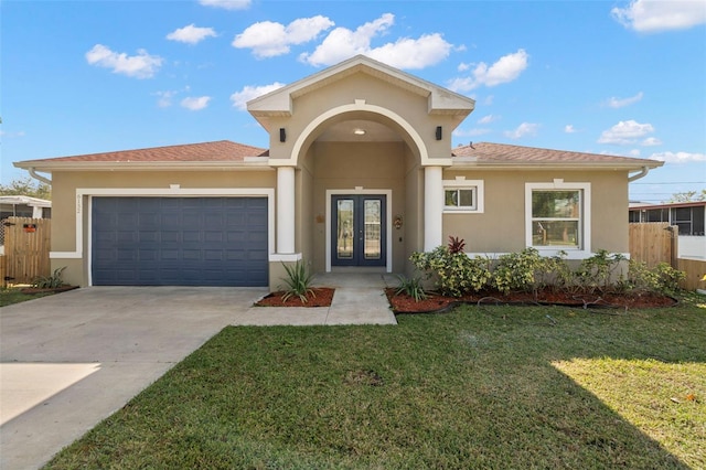 view of front of property with french doors, a front yard, and a garage