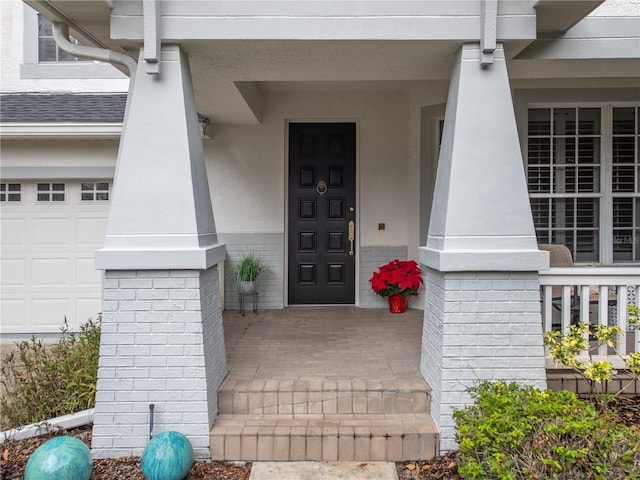 4709 Corsage Dr, Lutz, FL 33558 - view of exterior entry with a porch, stucco siding, brick siding, and a garage
