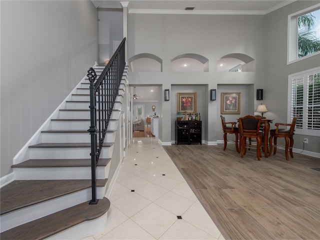 4709 Corsage Dr, Lutz, FL 33558 - staircase with ornamental molding, a high ceiling, and wood finished floors